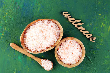 Wall Mural - Crystals of salt on table. himalayan salt in bowl and wellness letters made of wood