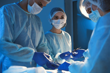 Poster - Team of professional surgeons performing operation in clinic