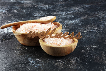 Wall Mural - Crystals of salt on table. himalayan salt in bowl and wellness letters made of wood