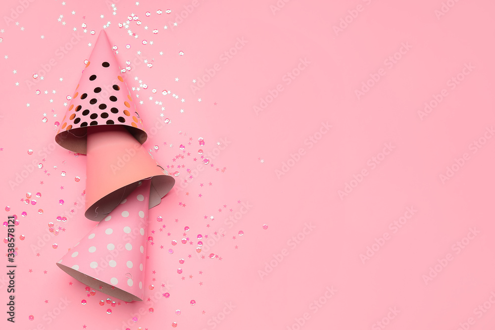 Birthday composition with party hats on color background
