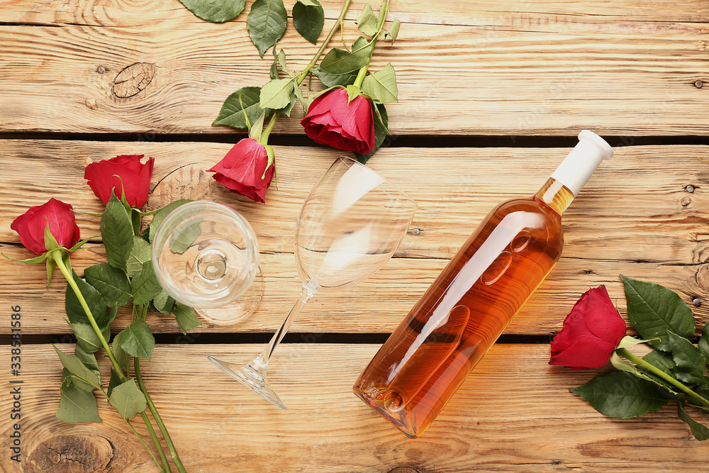 Composition with wine and roses on wooden background