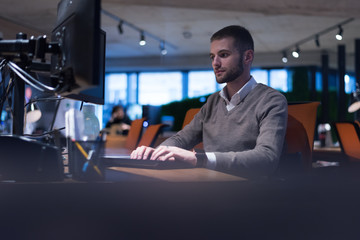 Young businessman working on computer in co work space. Coworking process, businessman working at modern office.