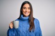 © Krakenimages.com - Young beautiful brunette woman drinking cup of coffee over isolated white background with a happy face standing and smiling with a confident smile showing teeth