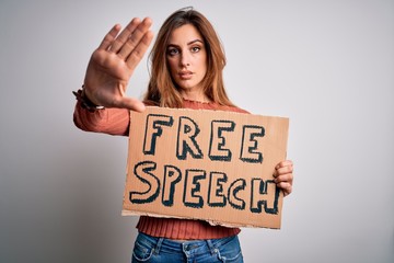 Young beautiful brunette woman asking for rights holding banner with free speech message with open hand doing stop sign with serious and confident expression, defense gesture