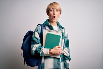 Sticker - Young blonde student woman with short hair wearing backpack and holding university books scared in shock with a surprise face, afraid and excited with fear expression