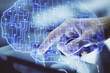 © peshkova - Double exposure of man's hand holding and using a digital device and brain hologram drawing. Data concept.