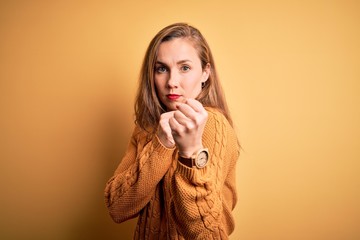 Sticker - Young beautiful blonde woman wearing casual sweater standing over yellow background Ready to fight with fist defense gesture, angry and upset face, afraid of problem