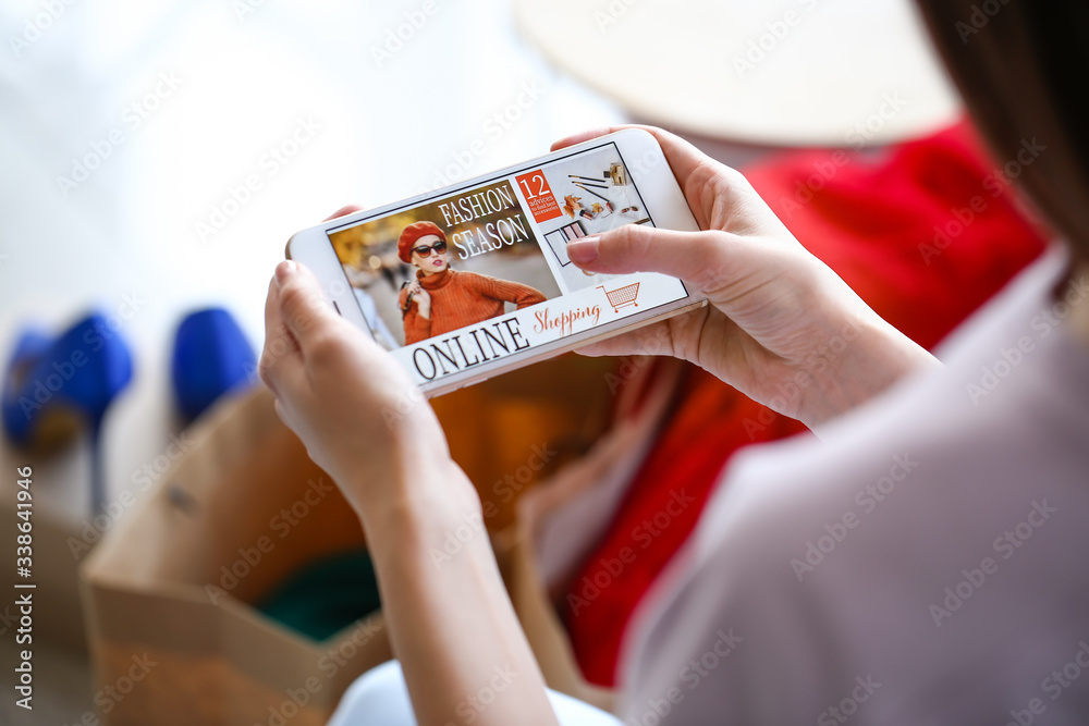 Young woman with mobile phone at home. Online shopping concept
