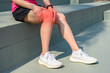Cropped shot of woman runner suffering from Iliotibial Band Syndrome (ITB). It cause from overuse injury causing pain on the outside part of the knee and outer thigh.