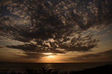 amanecer en el mar con nubes en el medio 