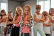 © Svitlana - Cool dancers. Portrait of positive little girls keeping arms crossed and smiling at camera while standing in the dance studio. Choreography class