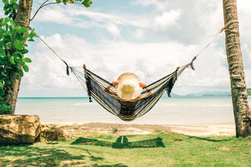 happy woman in black bikini relaxing in hammock