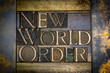 Photo of real authentic typeset letters forming New World Order text on vintage textured grunge copper background