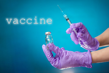 Vaccine. The doctor's hand in medical gloves holds a vial and a syringe for injection. Blue background. The concept of coronavirus, vaccines and health