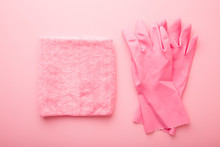 Rag And Rubber Protective Gloves For Different Surfaces Cleaning In Kitchen, Bathroom And Other Rooms. Pastel Pink Table Background. Closeup. Regular Cleanup. Top Down View.