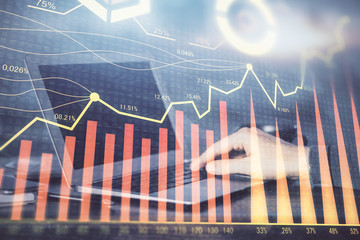 Double exposure of stock market graph with man working on laptop on background. Concept of financial analysis.