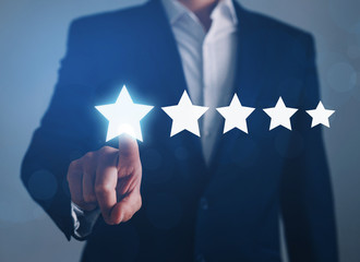 Businessman  touching five star symbol to increase rating of company.
Concept of satisfaction, quality and performance of services.
Copy space for  web banner.