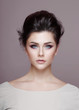 © Dragosh - Portrait of beauty fashionable model with superb makeup and hairstyle, looking at camera isolated on grey background.