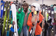 © JackF - Pair of young skiers choosing skis in sport goods store