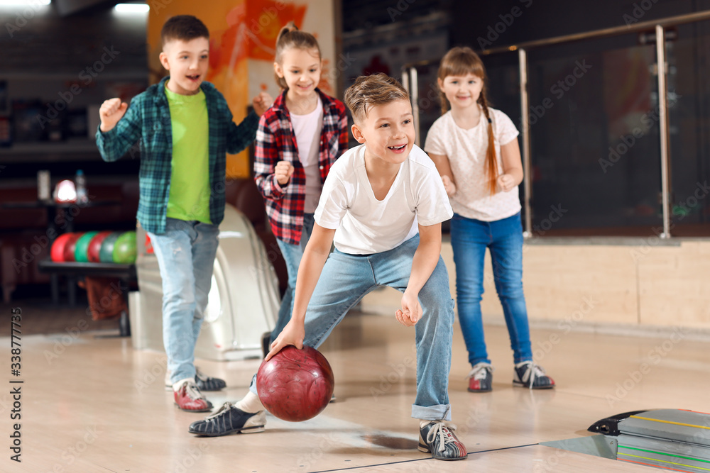 Little children playing bowling in club
