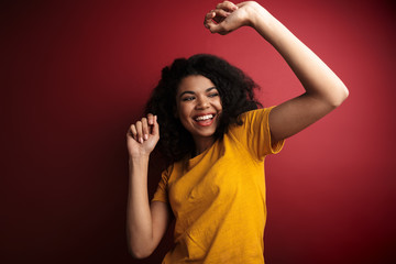 Wall Mural - Image of african american woman with curly hair smiling and dancing