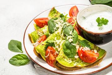 Green pancakes from spinach on white.