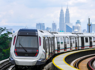 Malaysia Mass Rapid Transit (MRT) train with a background of Kuala Lumpur cityscape. People commute with MRT as transportation to work, school, travel, and shopping.