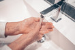 © Алина Троева - Hand washing lather liquid soap rubbing wrists handwash step senior woman rinsing in water at bathroom faucet sink. Wash hands for COVID-19 spreading prevention. Coronavirus pandemic outbreak.