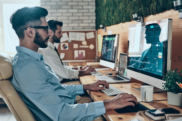 Two concentrated young modern men in formalwear working using co