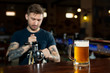 © Studio Peace - Bartender pouring from tap fresh beer into the glass in pub