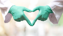 Thank You Coronavirus Helpers Concept. Hand Of Doctor In Heart Shape Isolated On Hospital Blur Background For Love And Care In Medical Healthcare.