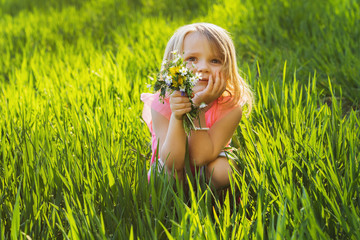 Wall Mural - little sweet girl on the meadow with flowers