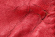 Shabby and worn red faux leather texture background with cracks and damages