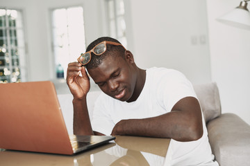 Wall Mural - A man of African appearance in front of a laptop