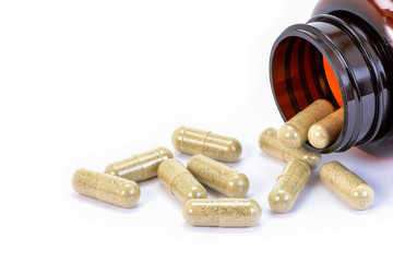 Sticker - Closeup herbal capsules pill in brown glass bottle isolated on old wood table background.