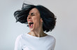 © My Ocean studio - Psychotic. Close-up photo of a young woman in a white t-shirt who is screaming loudly because of her bipolar disorder and a depressive episode.