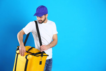 Canvas Print - Courier with thermo bag on light blue background, space for text. Food delivery service