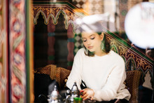 Portrait Of Pensive Young Woman Drinking Tea In A Tea Shop