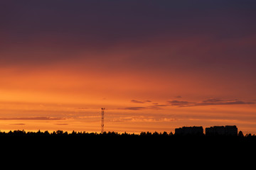 Building at the orange sunset over the forest