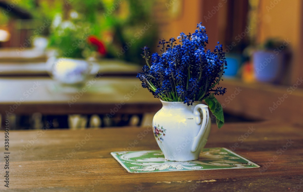 Vase With Blue Flowers On Table - obrazy, fototapety, plakaty 