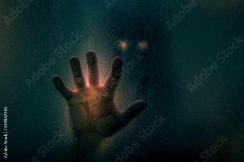 Cuadros en Lienzo Horror scene of a man with bloody hand against wet shower glass