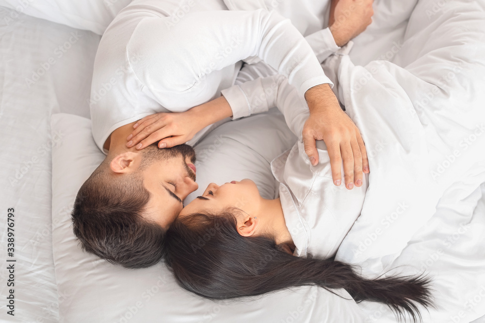 Young couple sleeping in bed at home