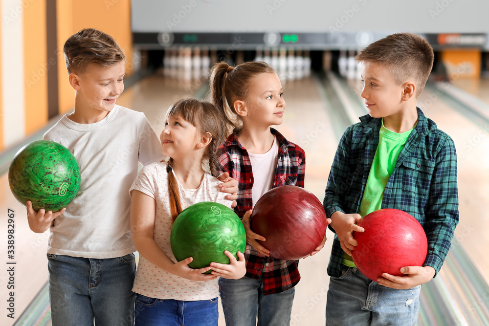 Little children playing bowling in club