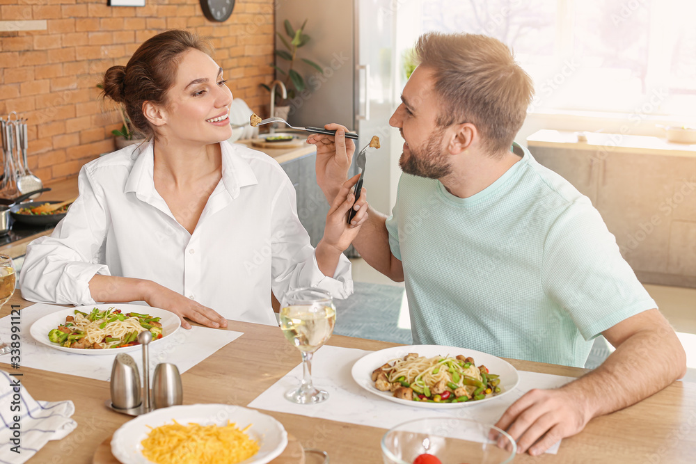 Happy young couple having lunch in kitchen