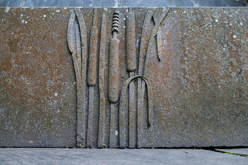 A botanical floral detail carved in a sandstone fountain basin, a water cane plant.