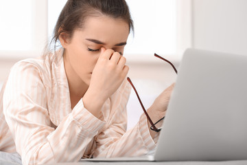 Sticker - Tired young woman working on laptop at home