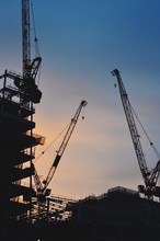 Low Angle View Of Silhouette Cranes At Construction Site