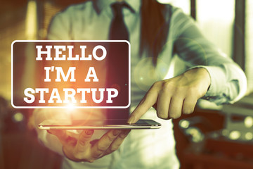 Poster - Handwriting text Hello I am A Startup. Conceptual photo Entrepreneur starting business Presenting New project Blurred woman in the background pointing with finger in empty space