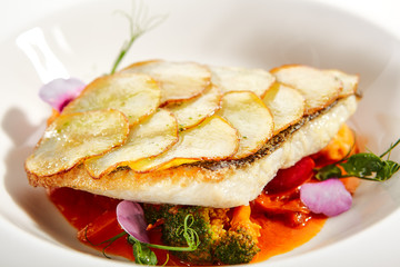 Canvas Print - Fried flounder fillet on baked potato slices