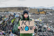© Halfpoint - Woman activist with placard poster on landfill, environmental pollution concept.